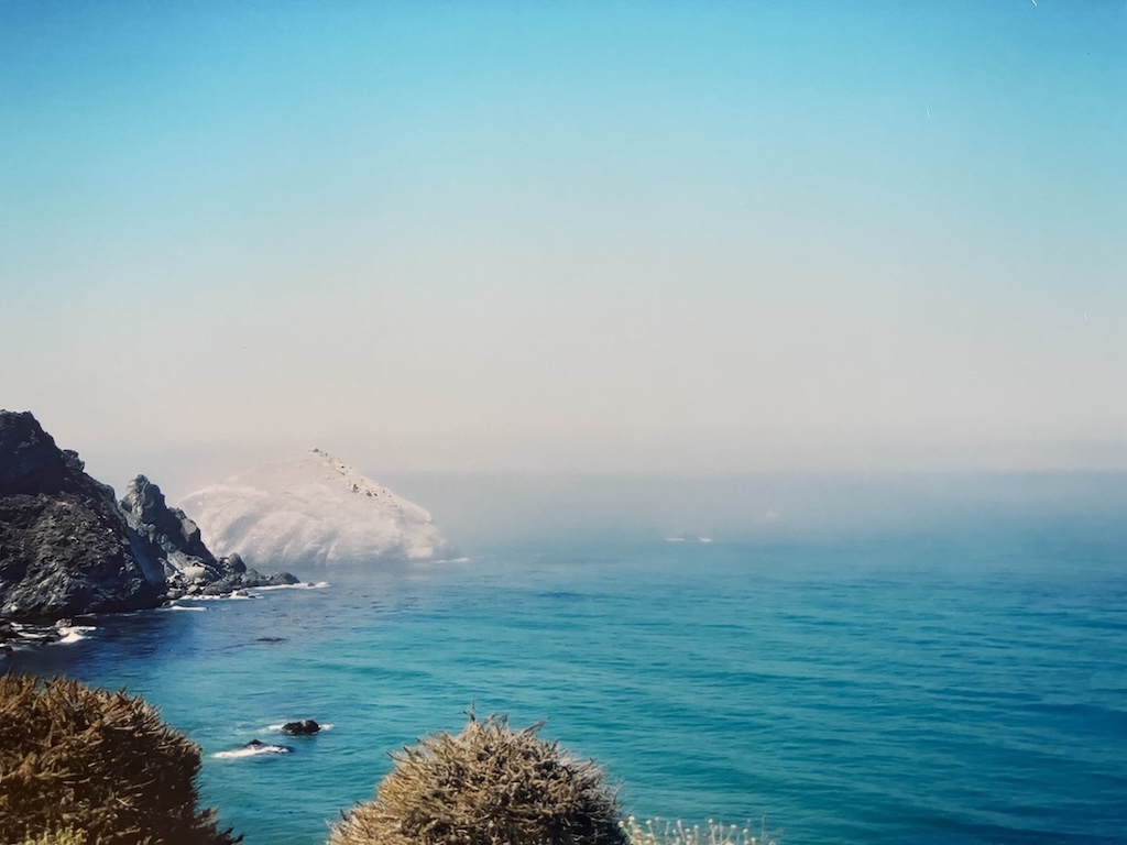 Highway 1: the ghostly shape that looks like a giant wave is a rock covered in guano
